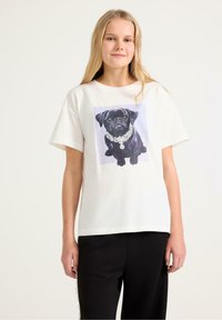 Vit bomulls t-shirt med en lila kantad grafisk bild av en svart mops prydd med ett smyckat halsband. Korta ärmar, avslappnad passform.