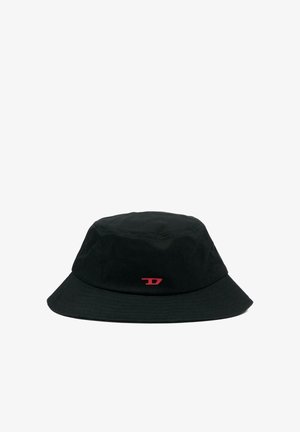 Chapeau seau noir avec un bord incliné vers le bas et un petit emblème rouge centré à l'avant.