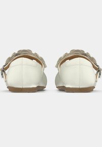 Άσπρα σανδάλια με λεία επιφάνεια, διακοσμημένο λουράκι με λουλούδι και ανθεκτική πλάτη. Λαστιχένιες σόλες προσφέρουν κράτημα και ανθεκτικότητα.