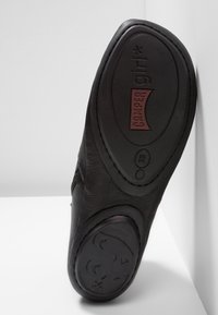 Semelle de chaussure en cuir noir affichant la marque "Camper girl", taille européenne 38, avec un motif de visage en relief sur la zone du talon.