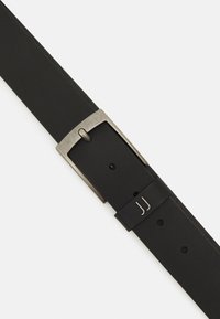 Ceinture en cuir noir avec une boucle en métal argenté rectangulaire, arborant un design minimaliste et deux accents argentés sur la sangle.
