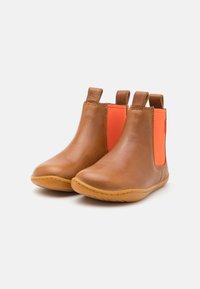 Botas de tobillo de cuero marrón con paneles elásticos laterales naranjas, puntera redondeada, detalles de costura y suelas de goma. Adecuadas para uso casual.