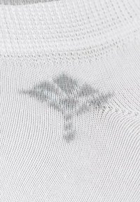 White textile with a fine mesh texture. Features a subtle gray emblem resembling a medical symbol on the surface.