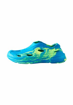 Blå og grøn slip-on træsko med flere ventilationshuller og en tekstureret sål, vist fra siden på en hvid baggrund.