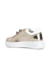 Metallisch goldene Sneakers mit weißen Akzenten, runder Zehenpartie, flacher Sohle, strukturiertem Obermaterial, dekorativen Schnürdetails und glattem Polster um den Kragen.