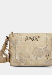 Borsa a spalla in finta pelle beige con motivo floreale stampato, dettagli in argento e ciondolo removibile. Presenta una chiusura a zip e una tracolla regolabile.