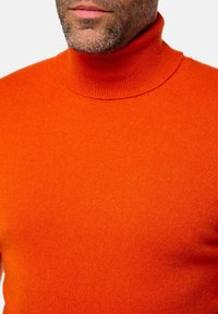 Oranger Rollkragenpullover aus geripptem Strickstoff, mit hohem Kragen und passgenauer Form. Weiche Textur ohne sichtbare Muster.