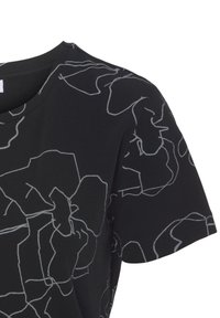 Camiseta negra de manga corta, con un patrón abstracto de líneas blancas en contraste. Material de algodón, con cuello redondo y textura suave.