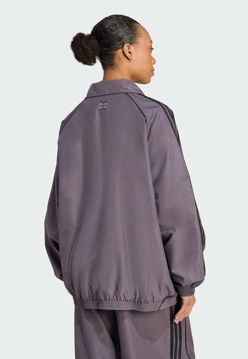 Gray satin jacket with a relaxed fit, elastic hem, and black stripe accents. Features a logo on the back and a collared neck.