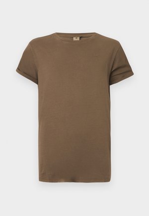 T-shirt de algodão castanho de manga curta com decote redondo e punhos dobrados, exposto contra um fundo branco liso.