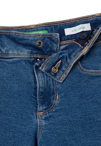 Džínové kalhoty v tmavě modré barvě s volným střihem. Obsahují zapínání na knoflík, kontrastní světlé švy a viditelné štítky na pasu.