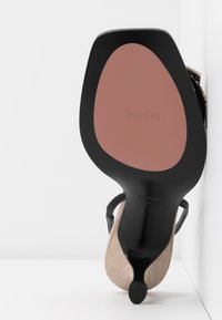 Chaussure noire à talon haut avec dessus en tissu beige, bout carré et semelle marron embossée de la marque "SPORTMAX".