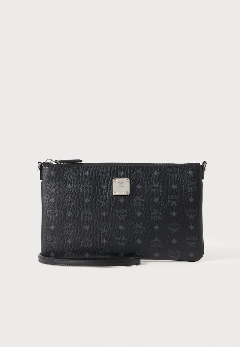 Pochette bracelet en cuir texturé noir avec motif monogramme subtil et plaque logo argentée centrée sur fond blanc propre.