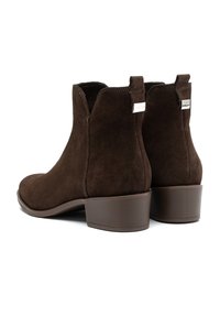 Ruske nubuk ankle čizme s blago šiljastim vrhom, zakrivljenim bočnim šavovima i glatkim smešnim potpeticama. Srebrni logo brenda na potpetici.