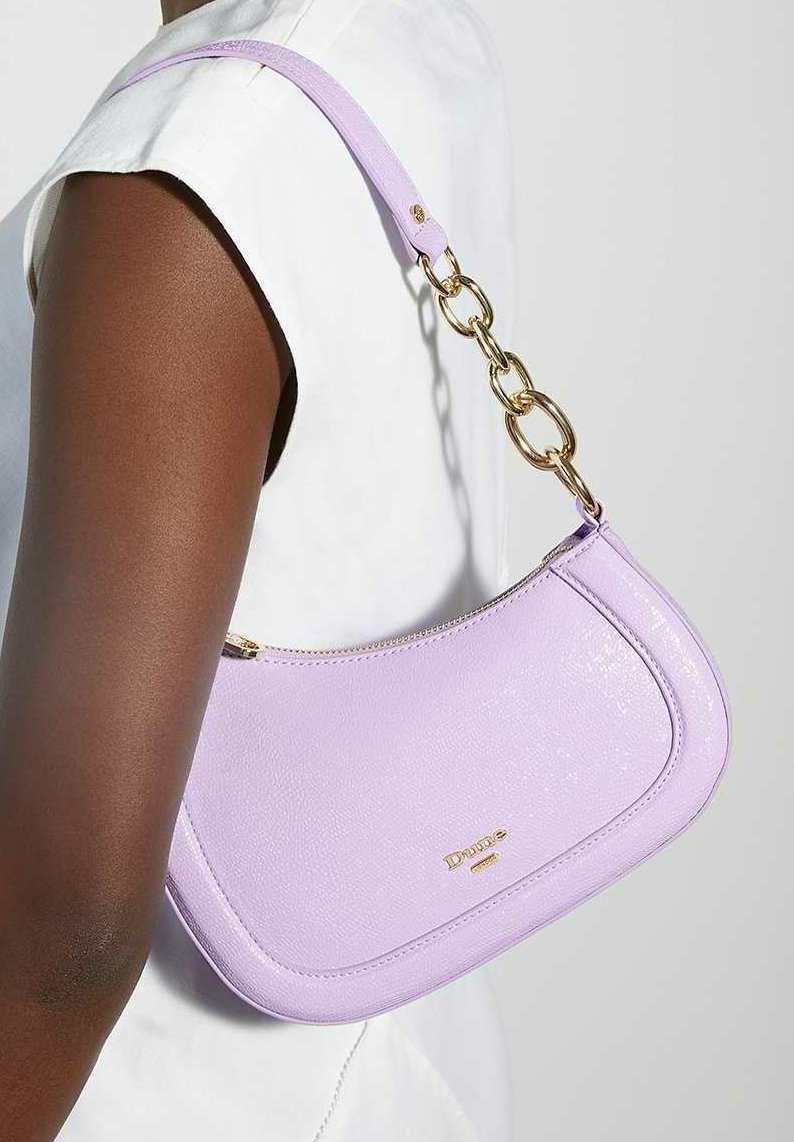 Sac à main en cuir lavande avec une silhouette incurvée, doté d'une bandoulière en chaîne dorée et d'une fermeture éclair. Accent logo doré à l'avant.