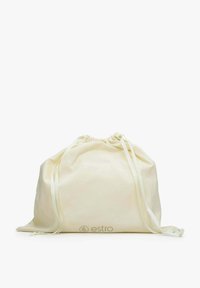 Worek sznurowany wykonany z jasnokremowej tkaniny z satynowymi wstążkami. Posiada subtelne logo w dolnym rogu oraz delikatną, gładką fakturę.