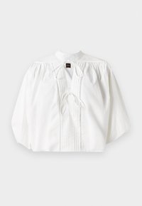 Blusa bianca con maniche a sbuffo arricciate, colletto alto, chiusura con cravatta frontale e pieghe verticali, realizzata in un tessuto leggero e testurizzato.