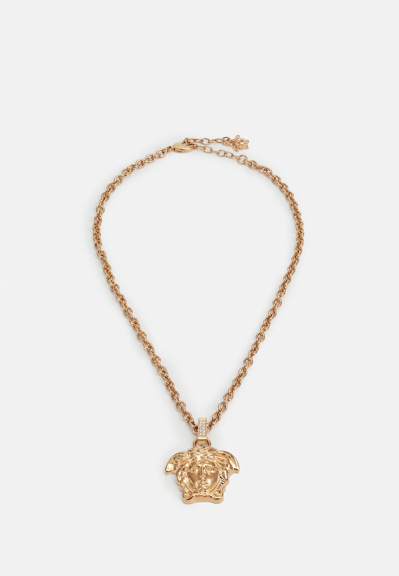 Zlate barve verižica z obeskom, ki prikazuje podrobno upodobitev Meduze, zasnovana s teksturirano strukturo in majhnimi gemstones akcenti na nosilcu, kar ustvarja udaren videz.