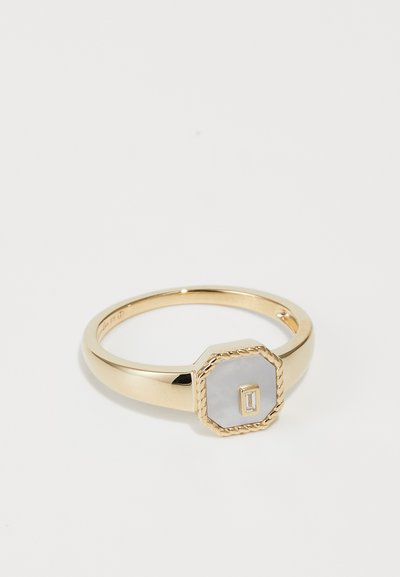 Bague en or avec un sertissage octogonal, présentant une pierre grise lisse et un petit accent rectangulaire ; détail en corde texturée autour de la pierre.