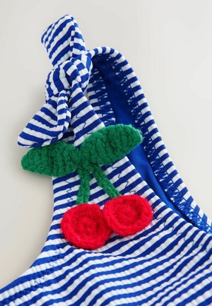 Stribet blå og hvidt stof med en knyttet accent. Har et grønt hækleblad og to røde hæklekirsebær som dekorative detaljer.