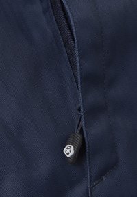 Tessuto di giacca blu navy con motivo a spina di pesce, caratterizzato da una chiusura con zip e un tirante in plastica nera con dettagli del logo.