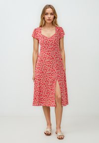 Rode bloemin midi-jurk met korte kapmouwen, v-hals, een zijsplit en een getailleerde taille, met kleine witte en gele bloemenpatronen.