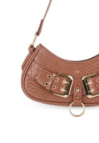 Bolso de hombro de cuero marrón texturizado con doble hebilla en tono dorado, ojales, tachuelas y un detalle central de anillo de metal.