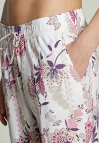 Lichte, gestreepte broek met bloemmotieven in roze, paars en crèmekleur. Rekbare tailleband met trekkoord en zijzakken.