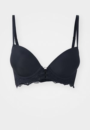Soutien-gorge rembourré noir avec bord en dentelle, présentant une surface lisse, des bretelles fines et réglables, ainsi qu'un détail décoratif à trois boucles au centre avant.