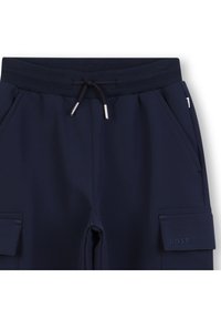 Calças azul-marinho em tecido macio com cintura ajustável por cordão, bolsos laterais e bolso cargo com detalhe do logotipo "BOSS" em relevo.