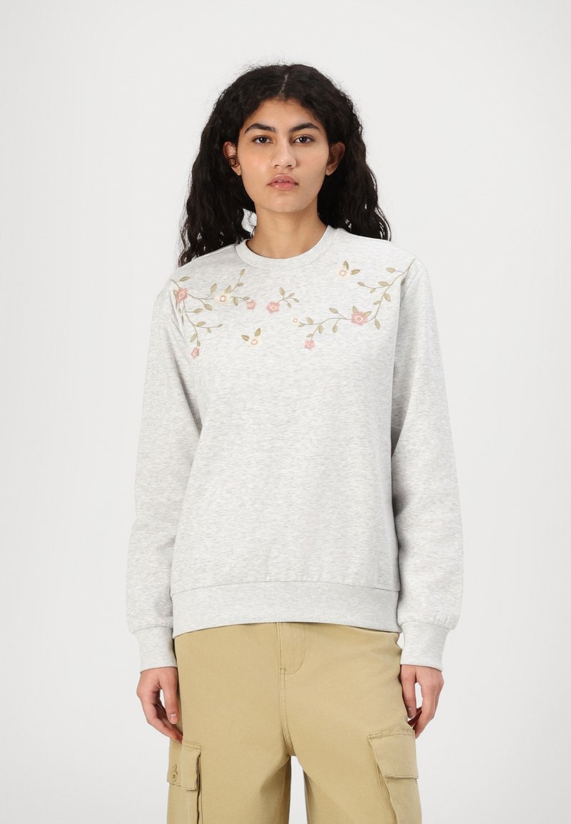 Grå sweatshirt i mjukt tyg, med blomsterbroderi i rosa och grönt över bröstet, samt ribbade ärmslut och nederkant.