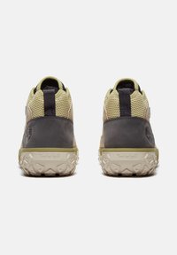 Timberland-skor med en grå läderkropp och ovandel av mesh. Har en tjock, texturerad sula och en grön accentrem runt hälen.