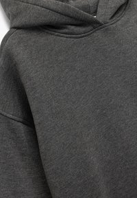 Tumma harmaa puuvillahuppari, jossa näkyvät huppu ja saumat, esittelee pehmeää tekstuuria ja lähellä otettu kuva ylärintakehän alueesta.