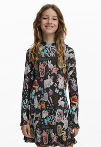 Langärmliges Kleid aus schwarzem Rippstoff mit bunten Cartoon-Motiven von Hasen, Sternen und Essen, ergänzt durch Textelemente.