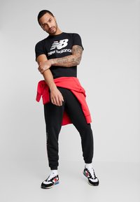 New Balance ESSENTIALS STACKED LOGO  - Camiseta estampada - black