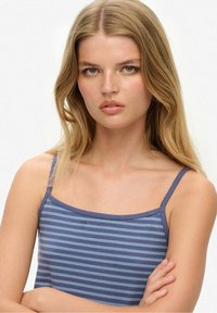 Camiseta de tirantes en rayas azul y azul claro, con una textura suave y un diseño ajustado. Sin patrones ni adornos adicionales.