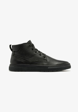 Botte noire en cuir montant à la cheville avec fermeture à lacets à l'avant, col rembourré, surface texturée et semelle en caoutchouc, présentée en profil latéral complet sur fond blanc.