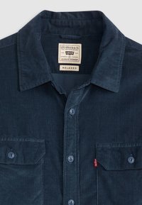 Navy Cord-Hemd mit Button-Down-Kragen, zwei Fronttaschen und lockerer Passform. Verfügt über ein Etikett mit der Aufschrift "Levi Strauss & Co."