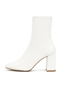 Botte blanche à la cheville en cuir lisse, dotée d'un bout pointu et d'un talon carré épais, avec une texture douce et un design minimaliste.