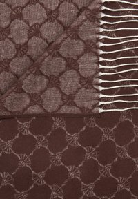 Bruine sjaal met patroon, gemaakt van zachte stof, met een geometrisch ontwerp en subtiele accenten. De franjes aan de randen zorgen voor textuur en detail.