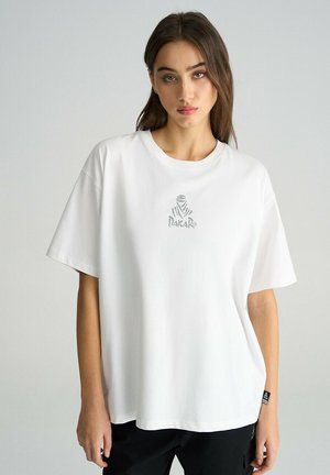 Biała koszulka z krótkim rękawem, wykonana z bawełny, z subtelnym logo "Dakar" i okrągłym dekoltem; luźny krój z gładką fakturą.