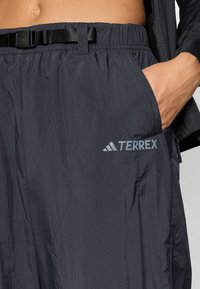 Črne kratke hlače Terrex iz teksturirane, lahke tkanine, z elastičnim pasom in pasom, ter poudarjenim logotipom spredaj.