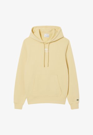 Sweatshirt à capuche jaune en tissu doux, avec une poche avant, des cordons de serrage et un petit logo blanc Lacoste sur la poitrine.