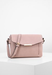 Piccola borsa a tracolla morbida di colore rosa con una chiusura rettangolare dorata e una tracolla regolabile, esposta su un podio bianco contro uno sfondo bianco.
