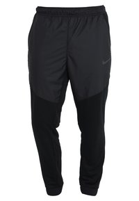 Musta urheiluhousut, joissa on kapeneva muotoilu, yhdistettyjä materiaaleja, sileä pinta, joustava vyötärö ja sivutaskut.