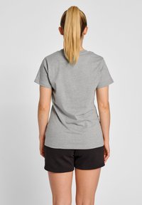 Grå, kortærmet t-shirt lavet af bomuldsblandingsstof, parret med sorte shorts. Pasformen er afslappet, med et simpelt, udetaljeret design.