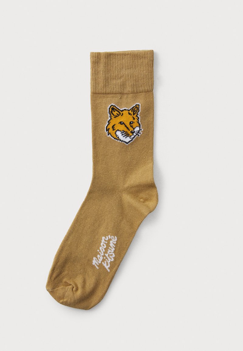 Chaussette de crew beige en tissu doux, avec un brodé de tête de renard en orange et noir, accompagné d'un texte blanc indiquant "Maison Petite" près de l'orteil.