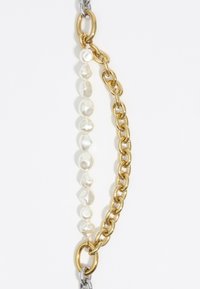 Pulsera de cadena de oro y plata que presenta perlas irregulares de diferentes tamaños, con textura suave y un brillo pronunciado. Conectada con grandes eslabones de metal.