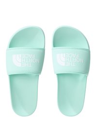 Light mint green slide sandals made of smooth synthetic material, featuring a wide strap with white logo text. Flat sole design.