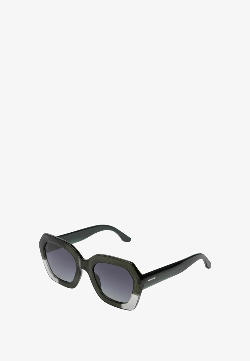 Oversized zonnebril met een donkergroene montuur, octagonale vorm en gradient lenzen die van donker naar licht overgaan.